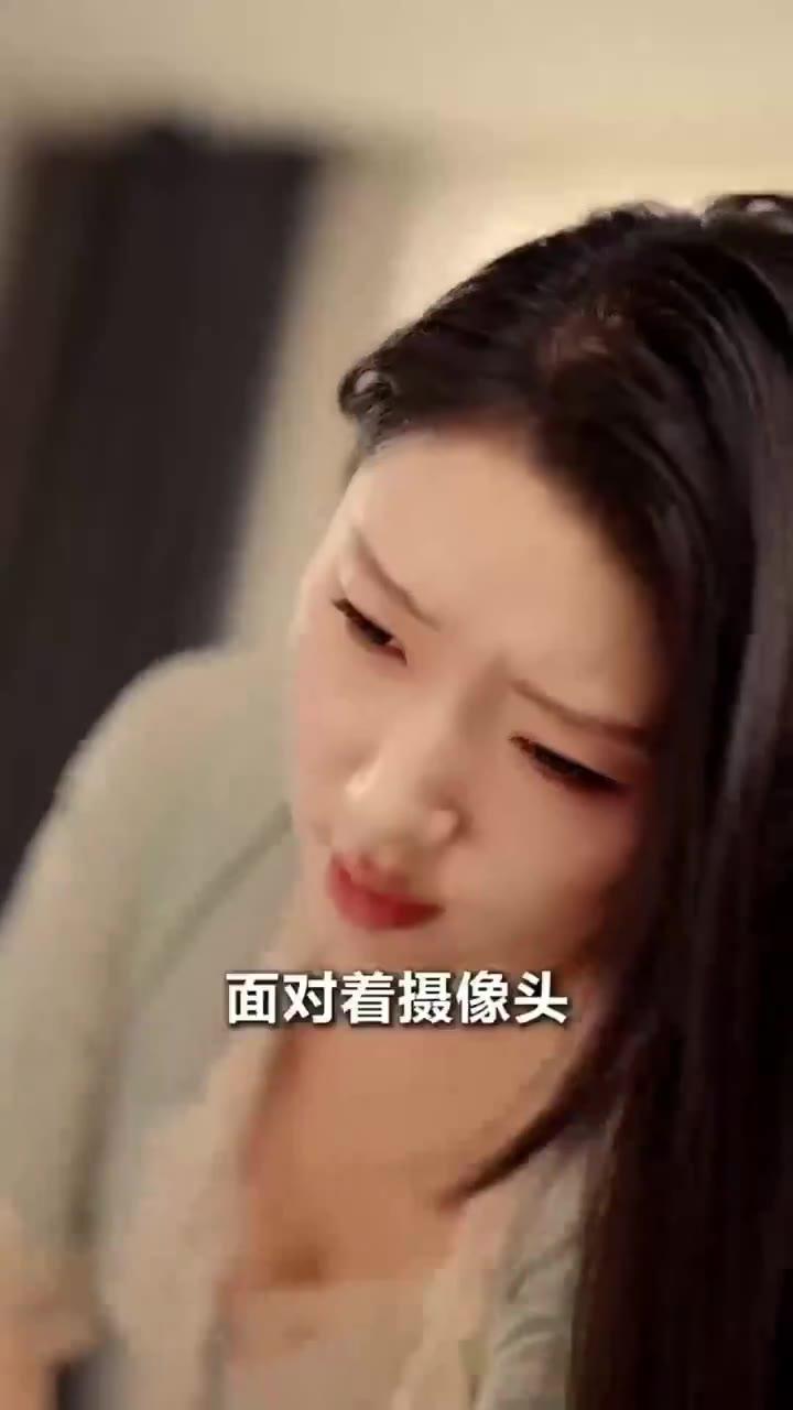 长发女性低头面对摄像头