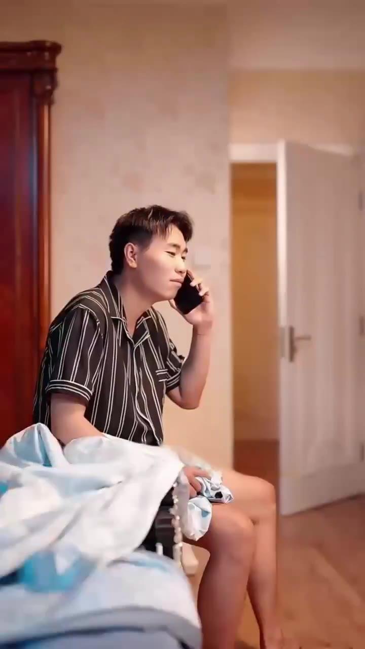 条纹睡衣男子在床沿打电话