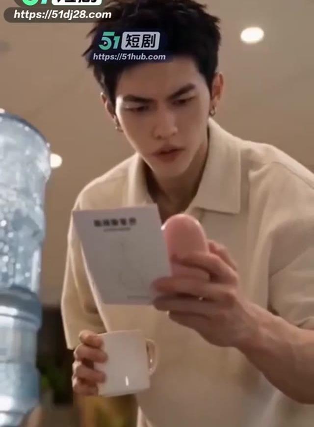 男员工在饮水处查看装置说明卡