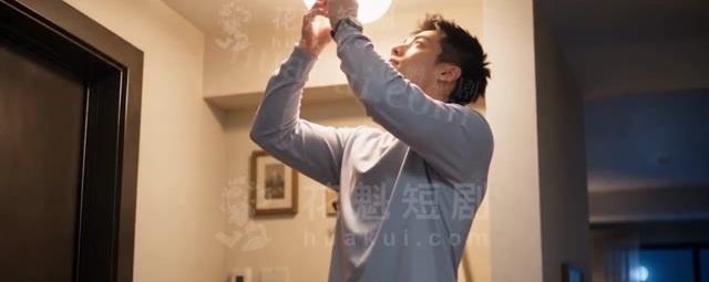 男子在公寓走廊帮邻居更换灯泡