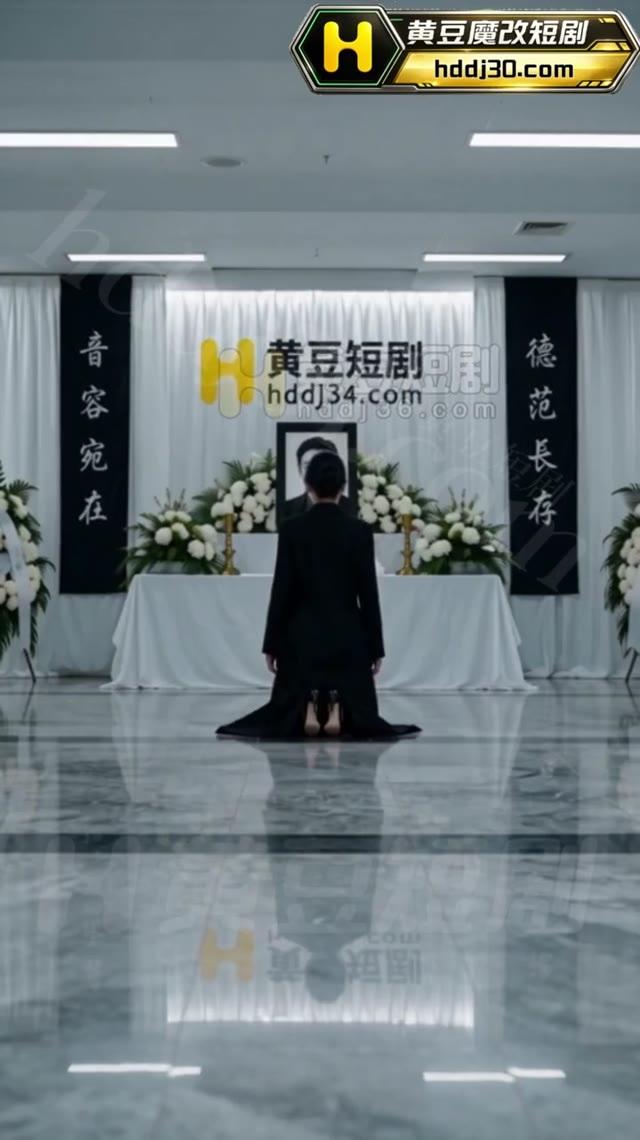 白色丧事陈设中有人面对遗像悼念