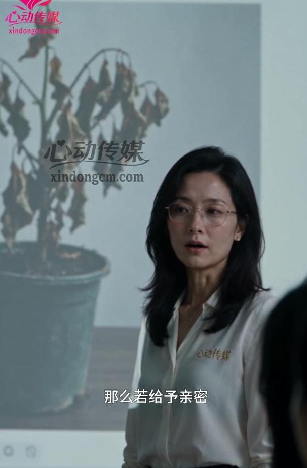 戴眼镜的研究人员在投影植物图前说明安排