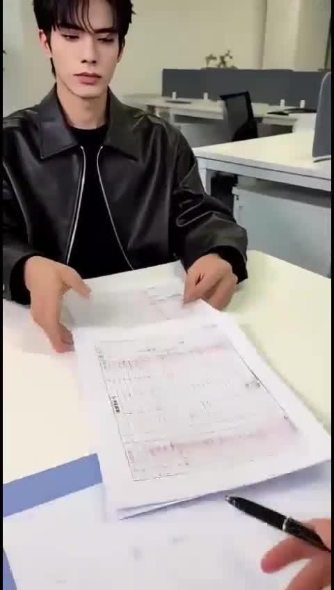 男职员在工作会议上翻阅文件
