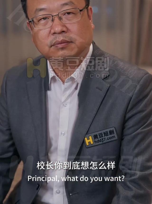 张校长穿灰色西装坐在室内